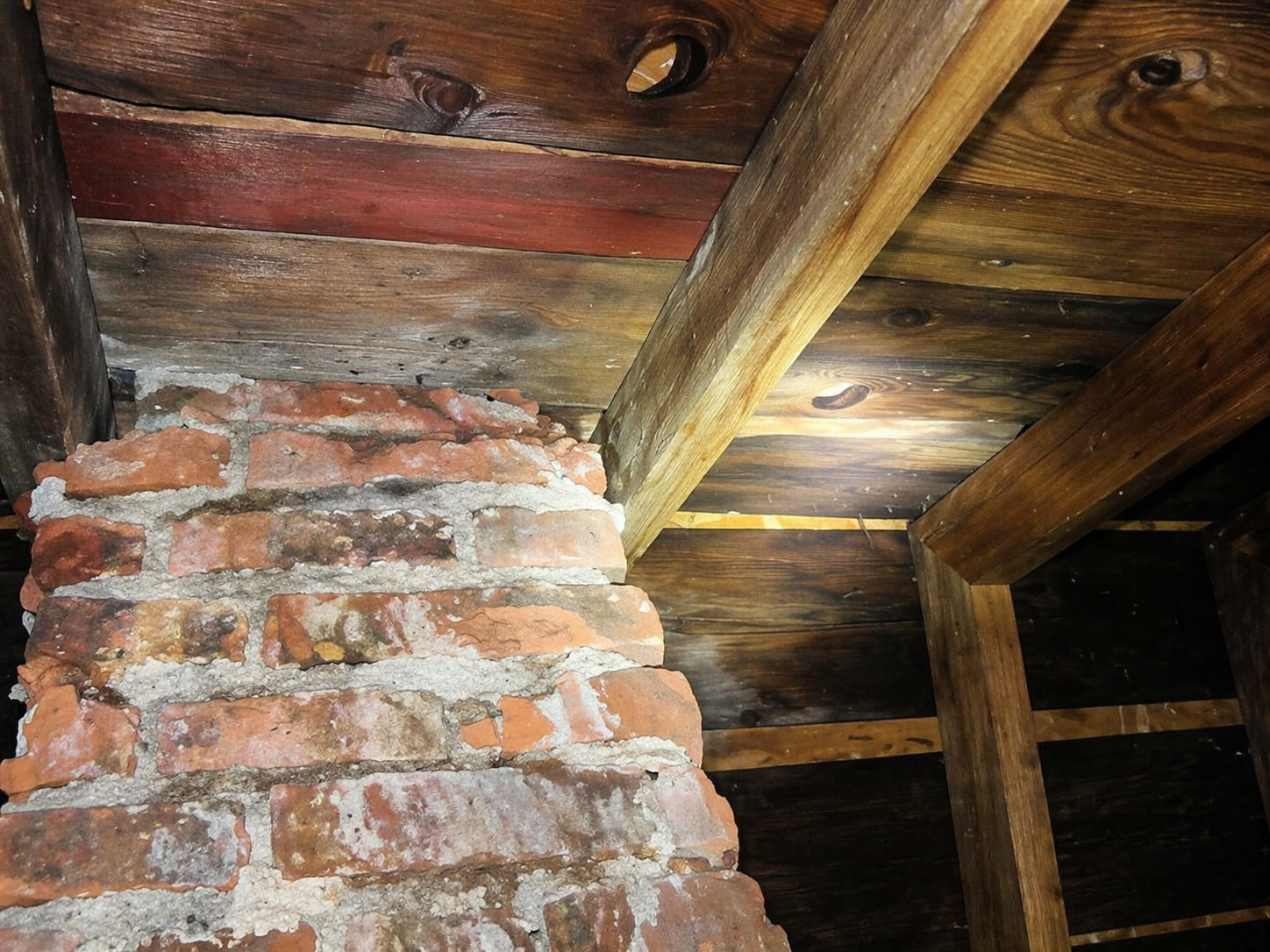 Albert Lea attic inspection — brick chimney penetration through rafters with flashing